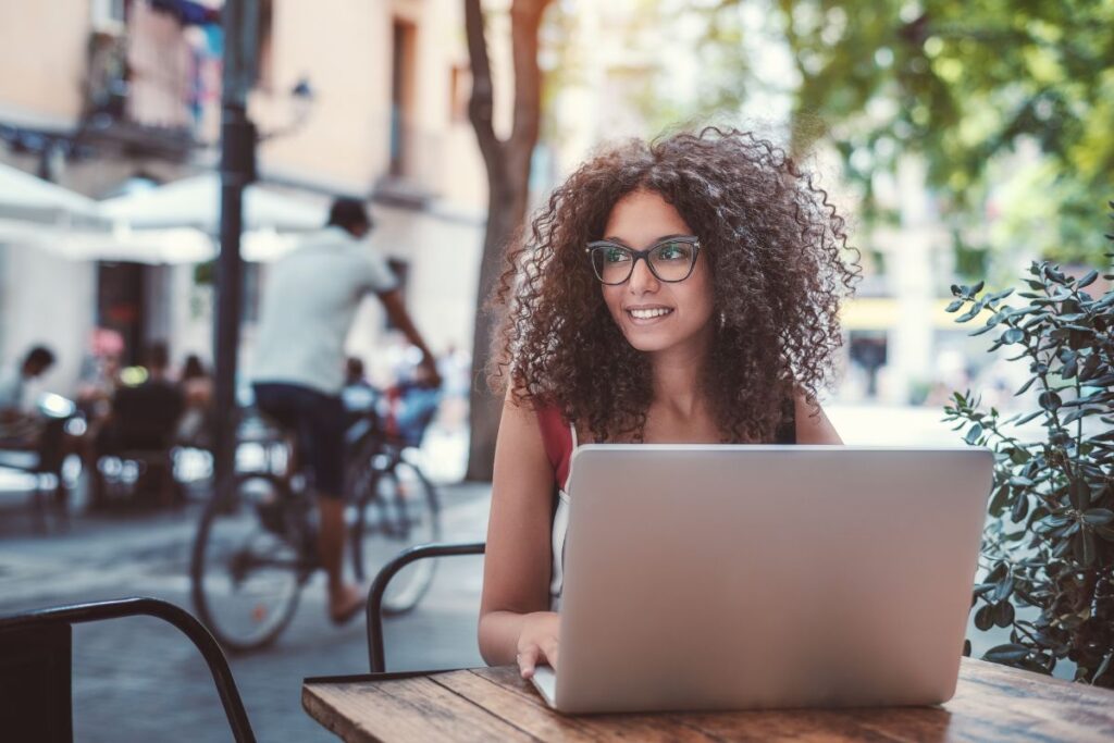 A woman working on her laptop outside a Barcelona Cafe