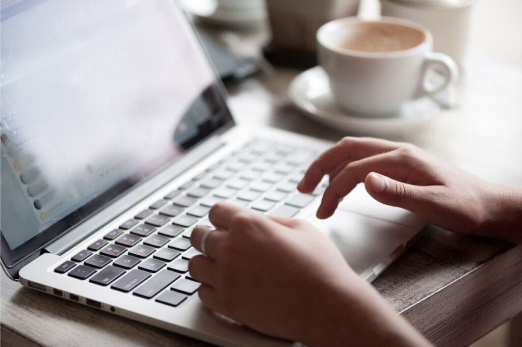 Barcelona Digital Nomad Guide - A Laptop in a cafe with a woman typing
